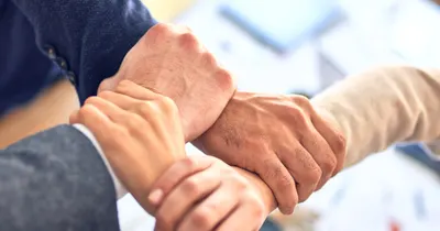 Mãos unidas de sócios, simbolizando uma sociedade empresarial