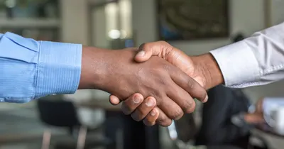 Aperto de mãos entre dois profissionais, simbolizando networking e confiança