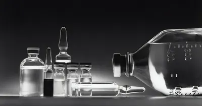 Frascos, ampolas e frasco de soro em imagem em preto e branco