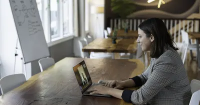 Profissional sorrindo durante atendimento on-line pelo computador