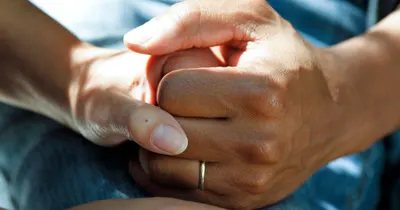 Mãos entrelaçadas representando o vínculo de confiança entre médico e paciente